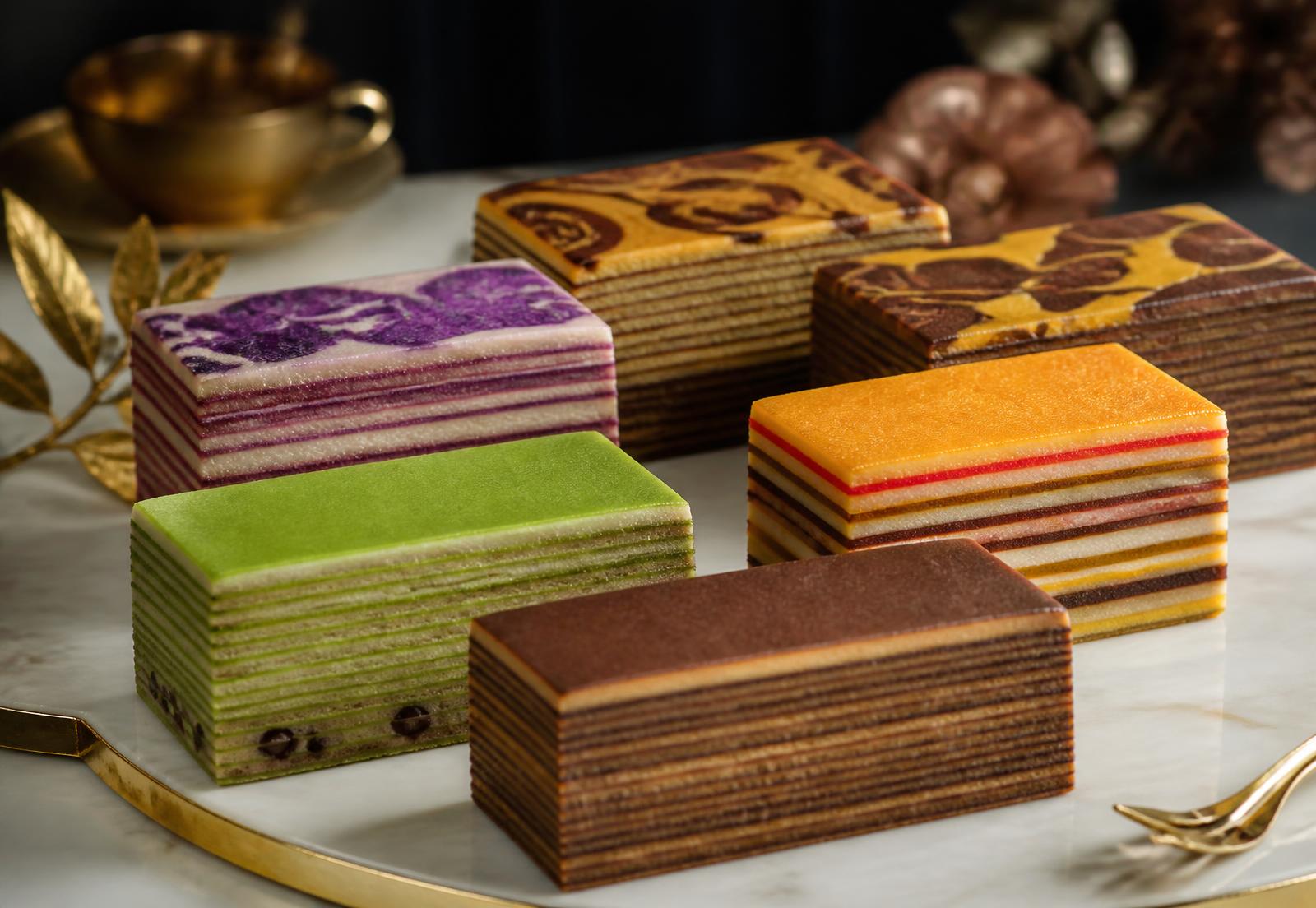 Aneka kek lapis berlapis warna-warni disusun di atas dulang